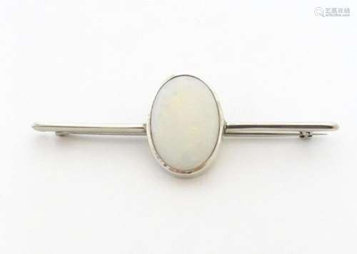 A 9ct white gold bar brooch set with central oval opal caboc...