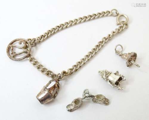 A white metal charm bracelet together with 5 pendant charms