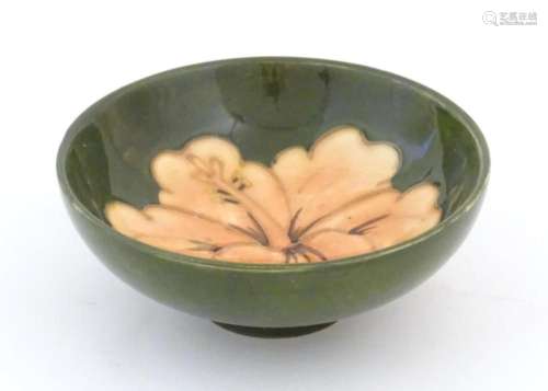 A small Moorcroft dish with hibiscus decoration. Marked unde...