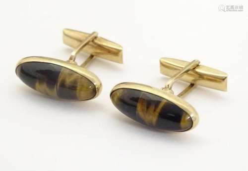 A pair of 9ct gold cufflinks set with tigers eye cabochon by...