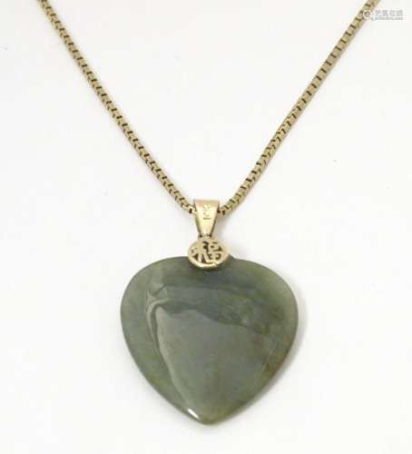 A green jade pendant of heart shape with yellow metal chain....