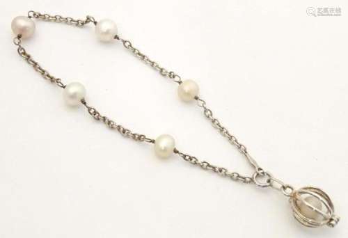 A silver and white metal bracelet set with pearls