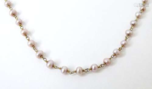 A pearl necklace set with pink pearls, with silver clasp. 18...