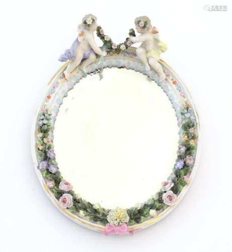 A Continental mirror with porcelain surround decorated in re...