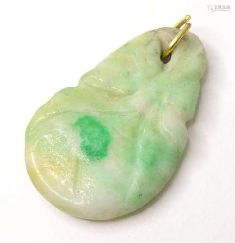A carved pendant of jade coloured hardstone approx. 1" ...