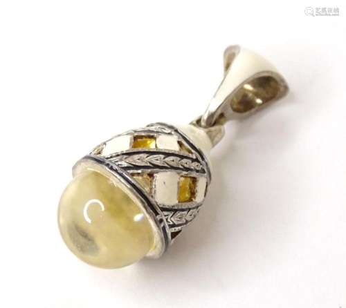 A Russian silver pendant charm of egg form with enamel decor...