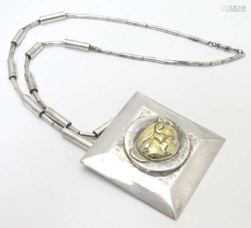 An unusual silver necklace with large square pendant with ha...