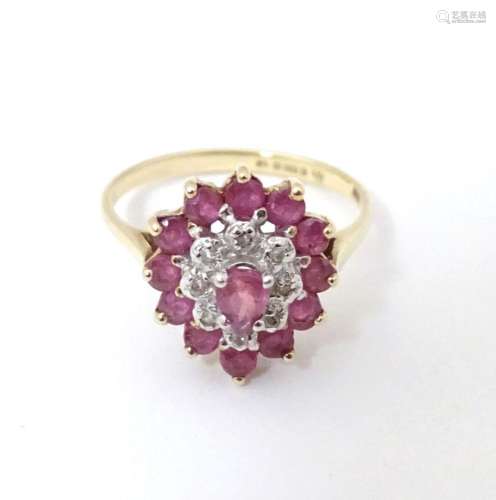 A 9ct gold ring set with central ruby bordered by diamonds a...