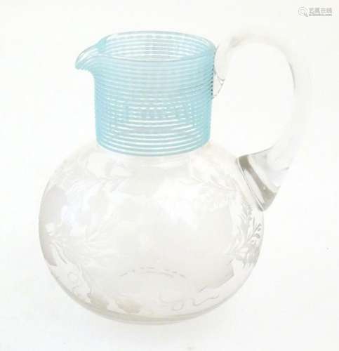 A Victorian water jug with engraved floral and foliate decor...