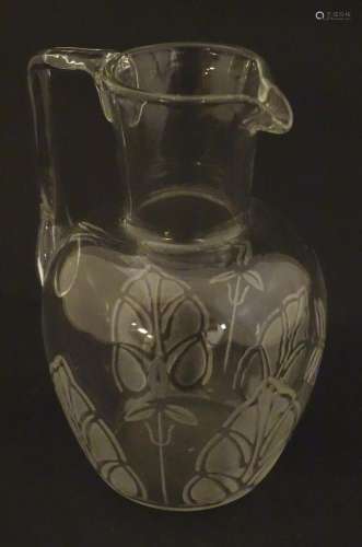 A glass water jug with foliate detail Approx 7" high
