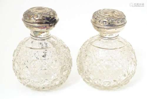 A pair of cut glass scent / perfume bottles with silver moun...
