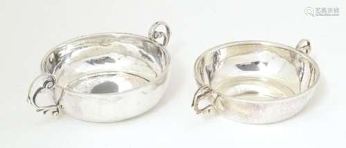 Two silver twin handled dishes, one with hammered decoration...