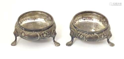 A pair of Victorian silver salts with embossed floral decora...