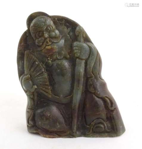 A Chinese carved jade figure depicting a man holding a fan a...
