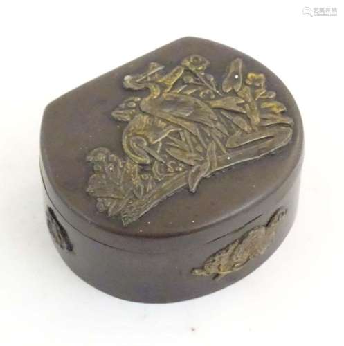 A Japanese lacquered brass stud box with a hinged lid, decor...