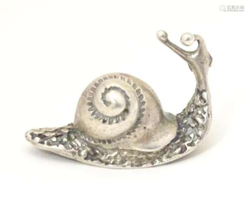 A small white metal model of a snail. Approx. 1 1/4" lo...