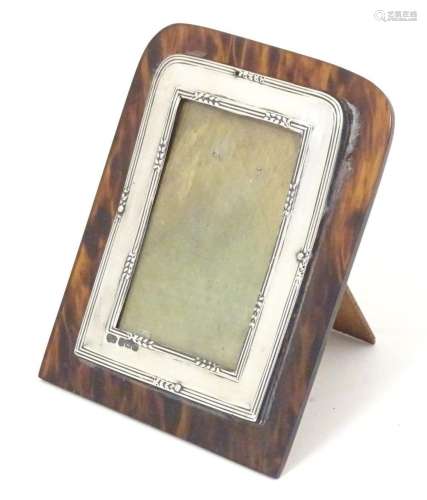 An easel back photograph frame with a silver surround border...