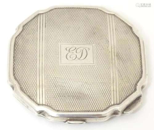 An Art Deco silver compact with engine turned decoration hal...