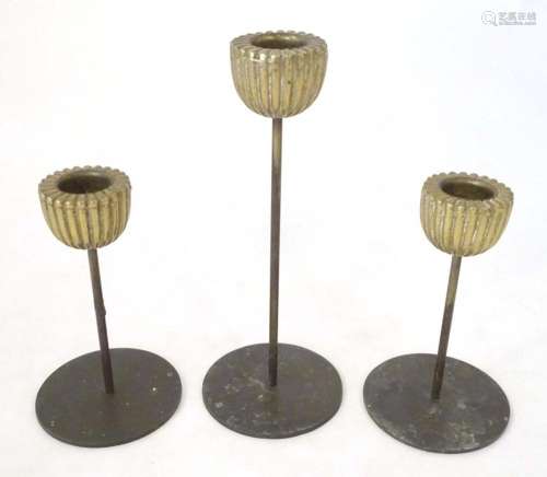 Three mid century modernist candlesticks, the reeded brass s...