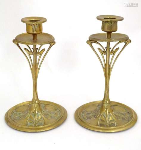 A pair of Art Nouveau brass candlesticks with tendril detail...