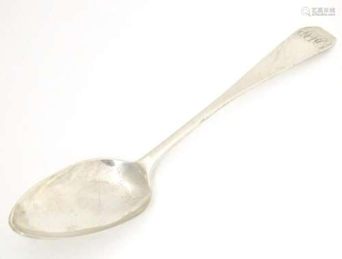 A white metal table spoon with coffin shaped top, marked J. ...