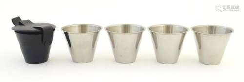 A cased travelling set of four stainless steel tot cups with...