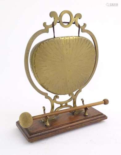 A 20thC brass table gong within a scrolling brass surround, ...