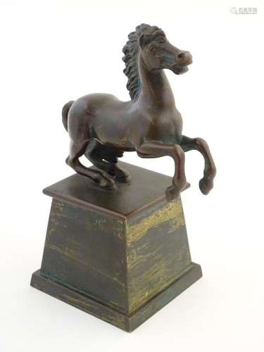 An early 20thC cast model of a rearing horse, on a tapered p...