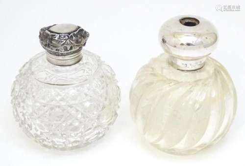 Two glass scent / perfume bottles with silver mounts / lids....