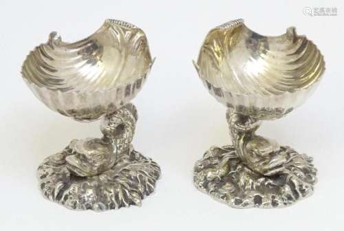 A pair of silver plate pedestal salts with shell formed bowl...