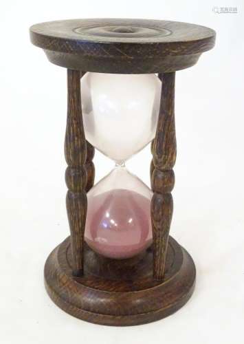 An early 20thC hourglass / sand timer with turned wooden end...