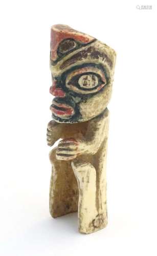 A North American carved bone figure with polychrome decorati...