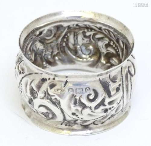 A silver napkin ring with embossed decoration hallmarked Bir...