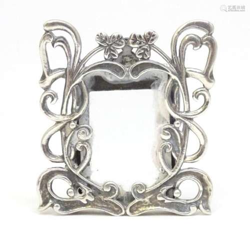 A miniature photograph frame with silver surround and clover...