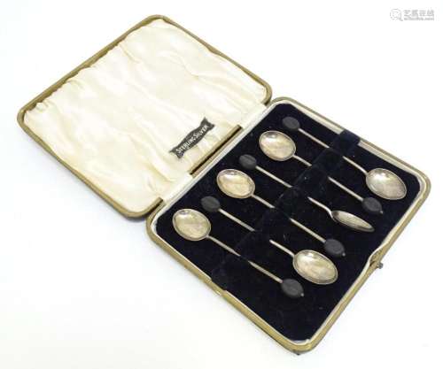 A cased set of six silver coffee spoons the handles surmount...