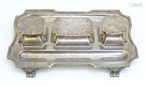 A silver standish with twin inkwells, central stamp section ...