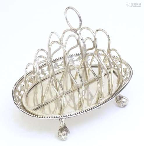 A silver 5-bar toast rack on oval base with pierced directio...