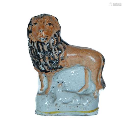 A Staffordshire pottery flat back figure of a lamb lying nex...