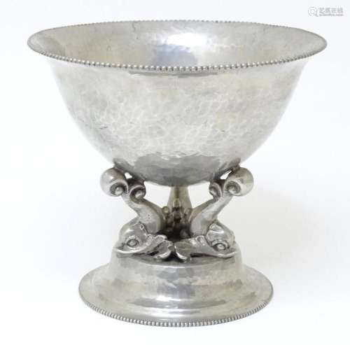 A Continental hammered metal pedestal bowl supported by Geor...