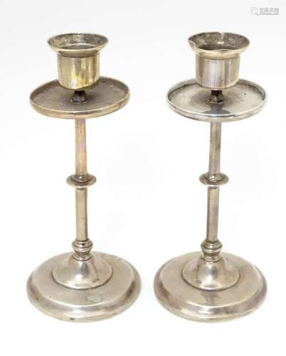 A pair of white metal candlesticks indistinctly marked and w...