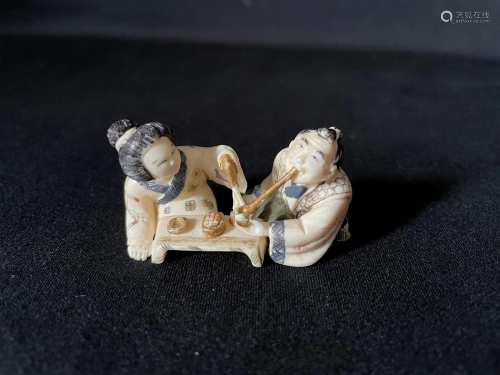 A Carved Cattle Bone Netsuke of Couples Smoking
