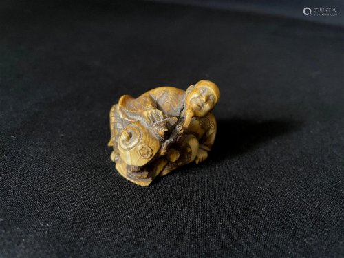 A Carved Cattle Bone Netsuke of Man and Turtle Dog