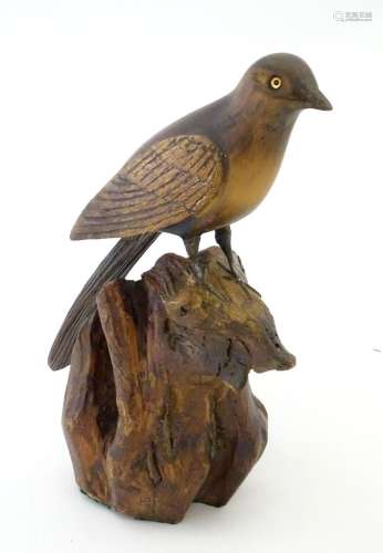 A 20thC carved wooden model of magpie / bird on a rocky outc...