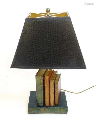 A novelty table lamp, the ceramic base formed as piled books...