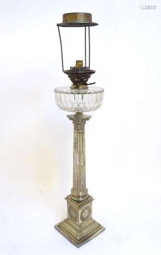 A 19thC oil table lamp, the silver plated base formed as a c...