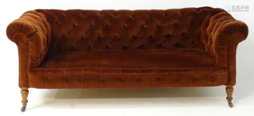A late 19thC button back chesterfield sofa raised on turned ...