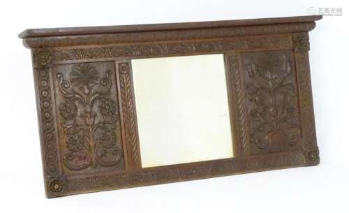 An early 20thC oak mirror with a moulded cornice above a nul...