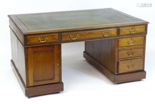 An early 20thC mahogany double pedestal partners desk, the d...