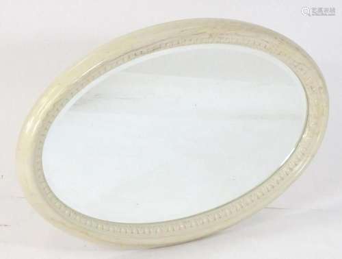 A mid / late 20thC white painted oval mirror with an egg and...