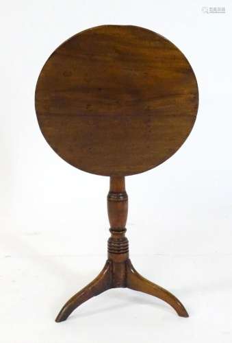A Georgian mahogany tripod table with a circular top above a...